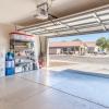 A garage with the door open. There are residential homes across the street with a truck in the driveway.