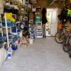 A garage with a lot of clutter in it. The garage has shelves that are flled with ll manner of materials.